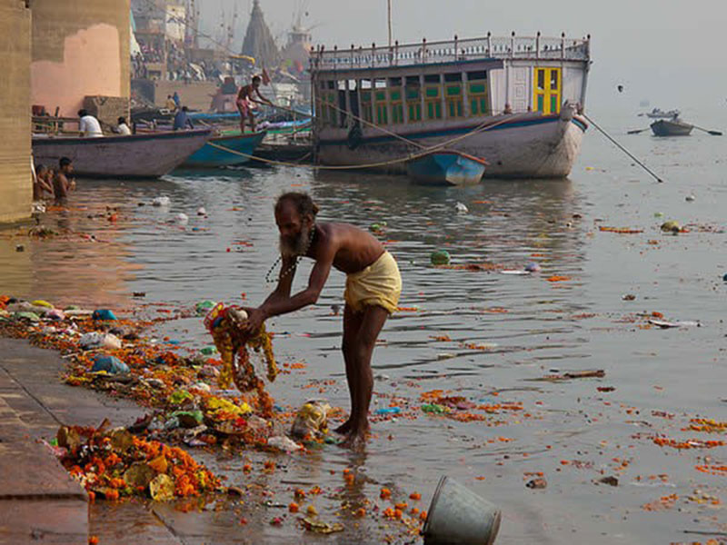 BEST POLLUTION IN THE WORLD - Déchets d'offrandes dans le Gange. Cet homme fait il le ménage ou pas ? © Photo sous Copyright