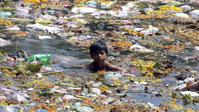 BEST POLLUTION IN THE WORLD - Un enfant se baigne dans les poubelles du Gange © Photo sous Copyright 