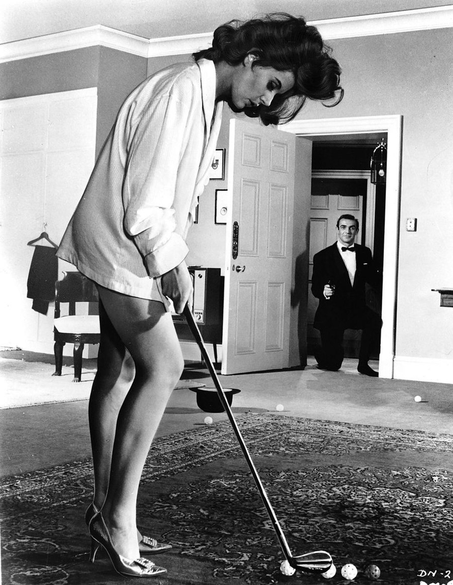 Sean Connery en James Bond devant une lagnifique femme ouant au golf sur un tapis