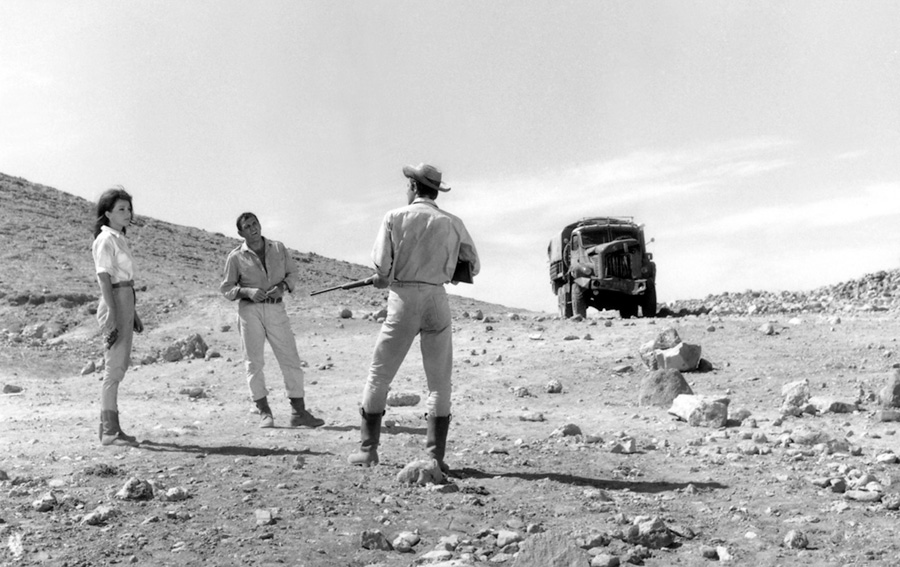 Jean-Paul Belmondo, fusil à la main devant Lino Ventura et Andrea Parisy dans le film "100 000 dollars au soleil" 
1964 © Photo sous Copyright