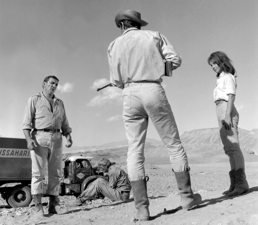 Jean-Paul Belmondo, fusil à la main devant Lino Ventura et Andrea Parisy dans le film "100 000 dollars au soleil" 
1964 © Photo sous Copyright