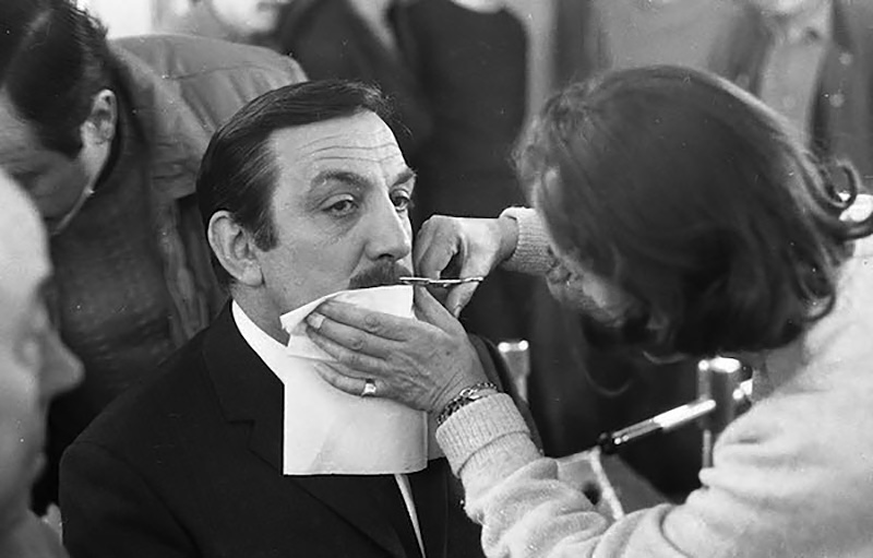 Une maquilleuse coupe la moustache de Lino Ventura, qui incarnera le rôle de Philippe Gerbier
pour le film "l'Armée des ombres" - 1969 © Photo sous Copyright