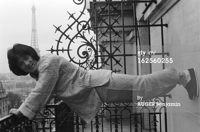 Jackie Chan dans une pose acrobatique devant la Tour Eiffel