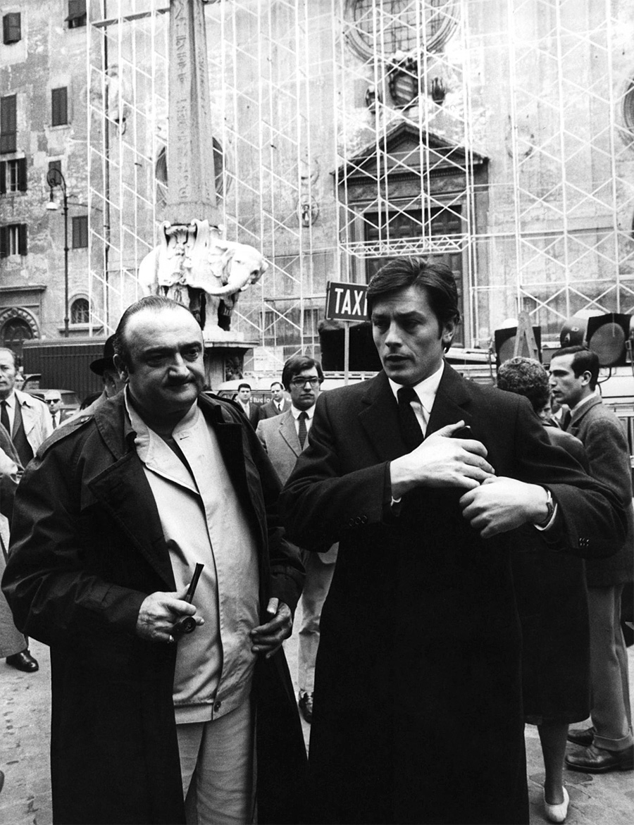Alain Delon et le réalisateur Henri Verneuil dans la rue pendant le tournage du film "Le clan des siciliens" - 1969 © Photo sous Copyright