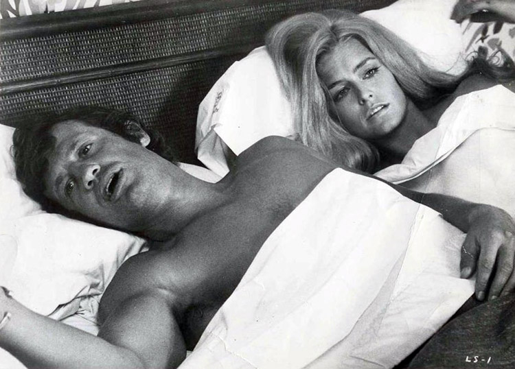 Photo de Jean-Paul Belmondo et Farrah Fawcett ensemble dans un lit.